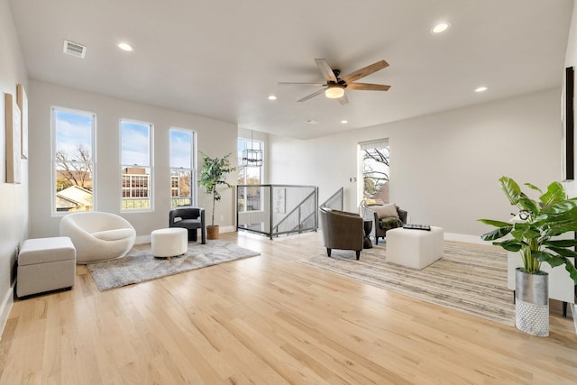 living area featuring light hardwood / wood-style floors and ceiling fan