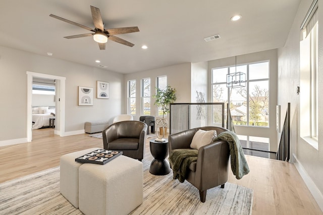 living room with ceiling fan and light wood-type flooring