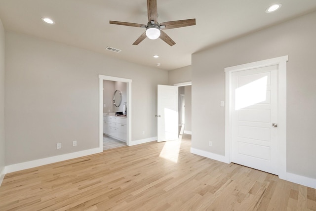 unfurnished bedroom featuring ensuite bathroom, ceiling fan, and light wood-type flooring