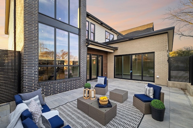 patio terrace at dusk featuring an outdoor living space