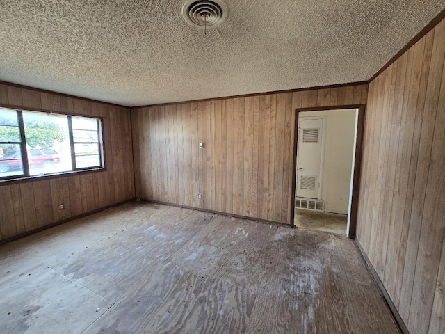 unfurnished room featuring wood walls