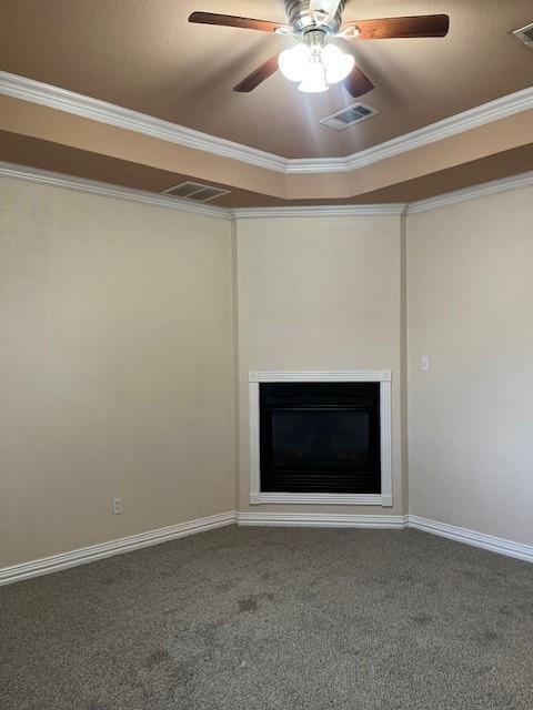 unfurnished living room featuring carpet flooring, ornamental molding, and ceiling fan