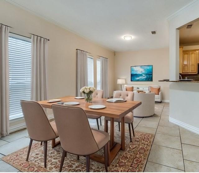 dining room with ornamental molding and light tile patterned floors