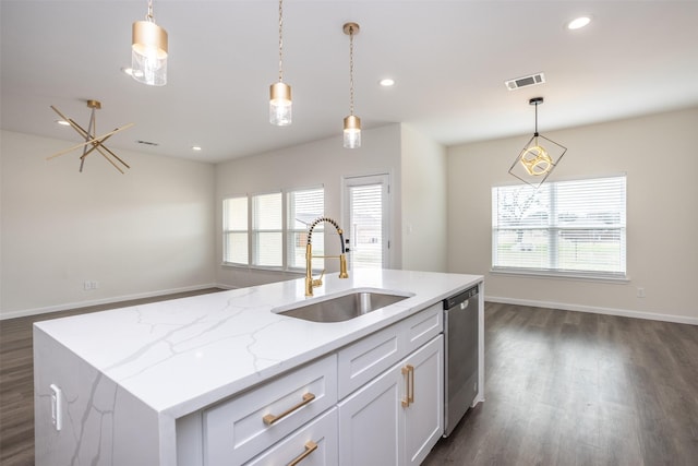 kitchen with decorative light fixtures, dishwasher, a center island with sink, sink, and white cabinets