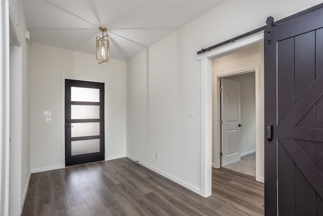 entrance foyer with a barn door and dark hardwood / wood-style floors