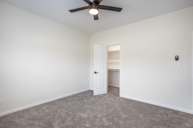 unfurnished bedroom with ceiling fan, light colored carpet, a closet, and a walk in closet