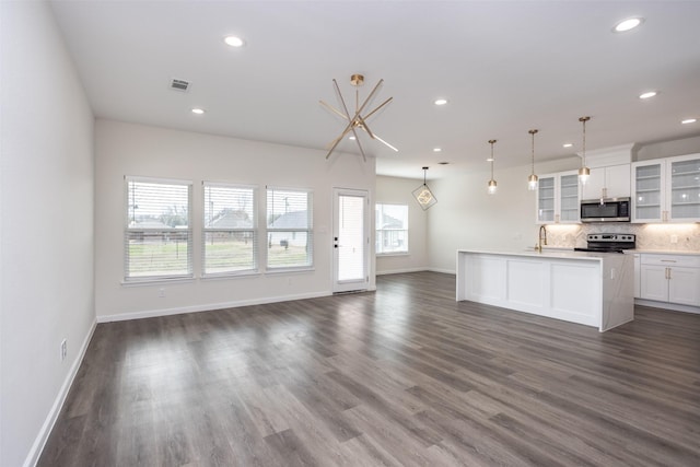 kitchen featuring a center island with sink, stainless steel appliances, pendant lighting, white cabinets, and sink