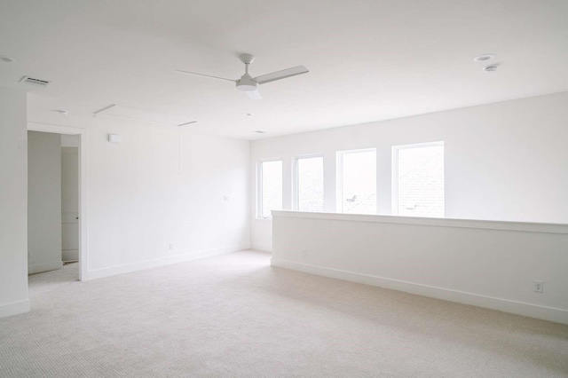 carpeted spare room featuring ceiling fan