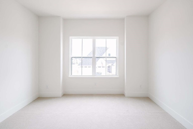 spare room featuring light colored carpet