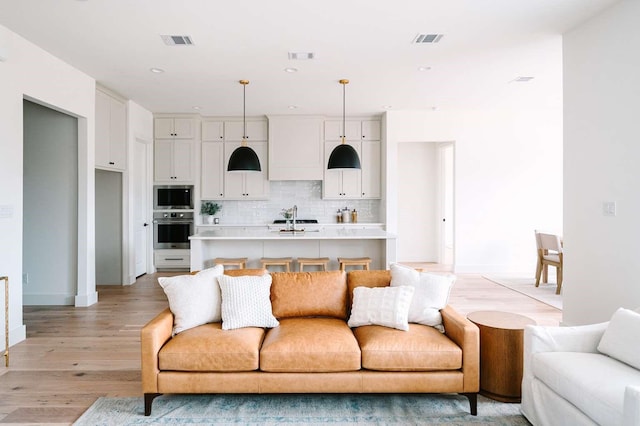 living room with light wood-type flooring and sink