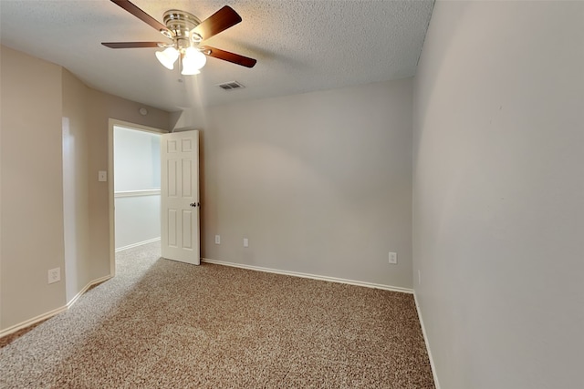 empty room featuring a textured ceiling, visible vents, and carpet flooring