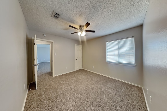 unfurnished bedroom with baseboards, visible vents, ceiling fan, a textured ceiling, and carpet flooring