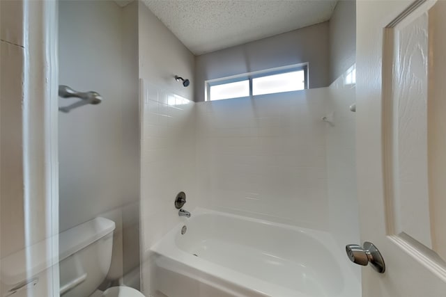 bathroom featuring a textured ceiling, shower / bath combination, and toilet