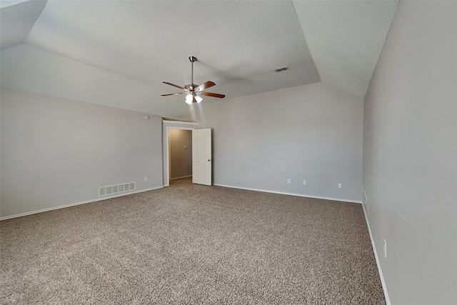 unfurnished room featuring carpet floors, lofted ceiling, visible vents, and a textured ceiling