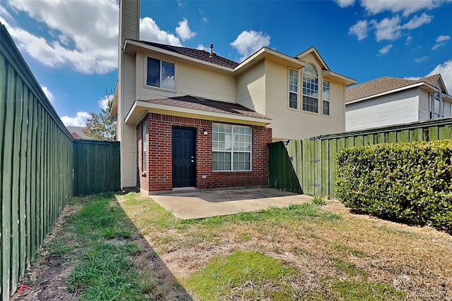 back of house featuring a patio, brick siding, and a fenced backyard