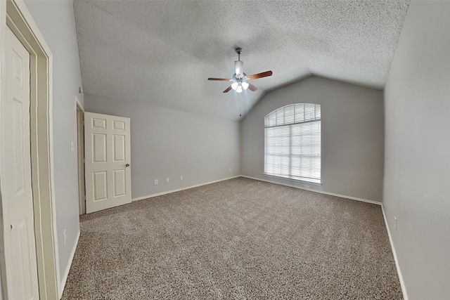 carpeted spare room with lofted ceiling, a textured ceiling, and baseboards