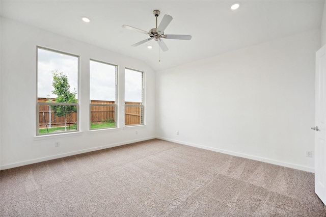 empty room with lofted ceiling, ceiling fan, and carpet