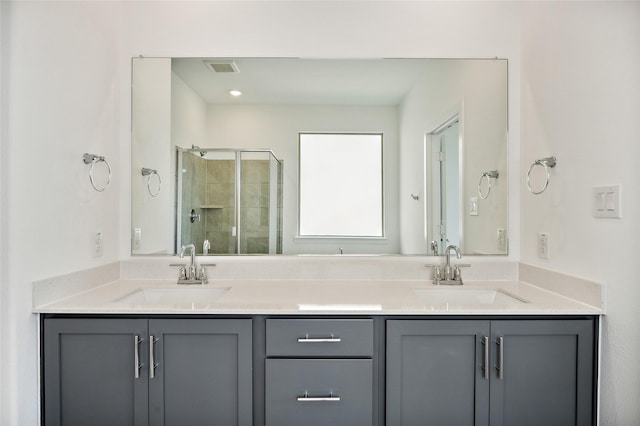 bathroom featuring a shower with door and vanity