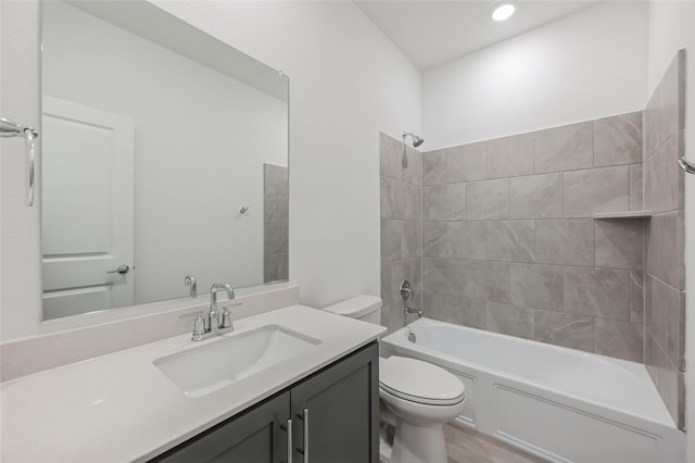 full bathroom with toilet, vanity, and tiled shower / bath