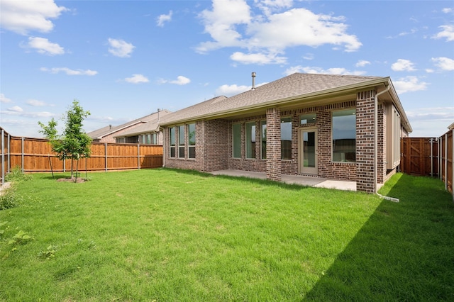 rear view of property featuring a yard and a patio