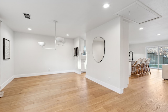 unfurnished room with sink and light hardwood / wood-style floors