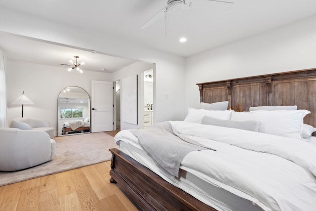 bedroom featuring light hardwood / wood-style flooring and ceiling fan with notable chandelier