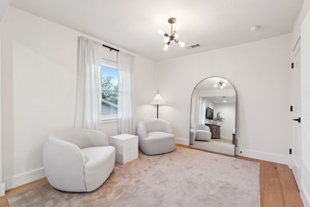 living area featuring light hardwood / wood-style floors and a notable chandelier