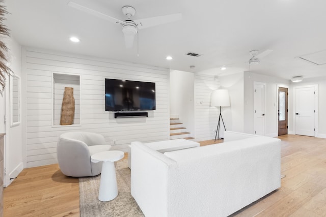 living room featuring wood walls, ceiling fan, and hardwood / wood-style flooring