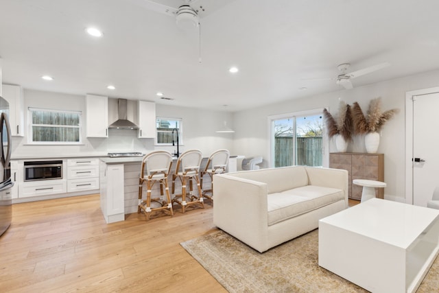 living room with light wood-type flooring and ceiling fan