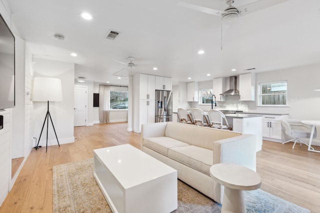 living room with ceiling fan, a healthy amount of sunlight, and light wood-type flooring