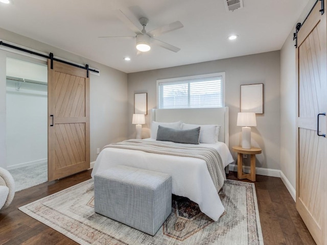 bedroom featuring a closet, ceiling fan, hardwood / wood-style flooring, and a barn door