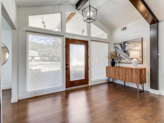 entrance foyer with dark wood-type flooring, french doors, a chandelier, and vaulted ceiling with beams