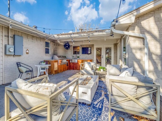 view of patio / terrace featuring an outdoor kitchen, an outdoor living space with a fire pit, and a grill