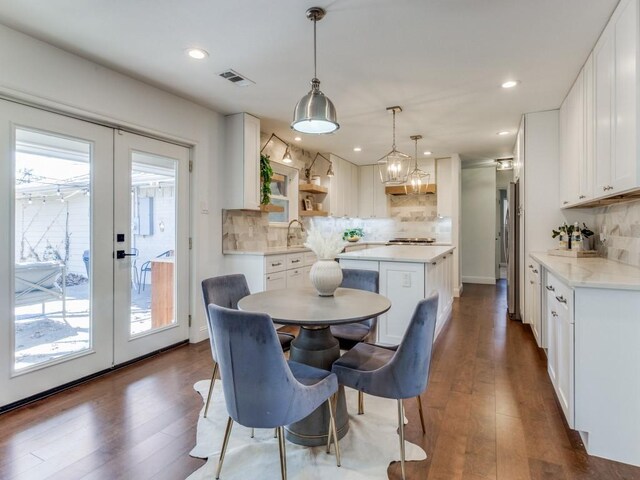 dining space featuring sink, french doors, and dark wood-type flooring