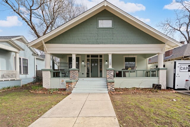 view of front of property with covered porch and a front lawn