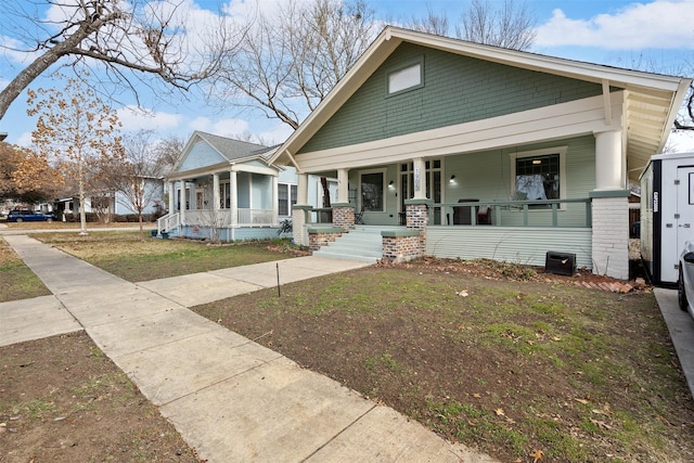 bungalow-style home with a front lawn and covered porch