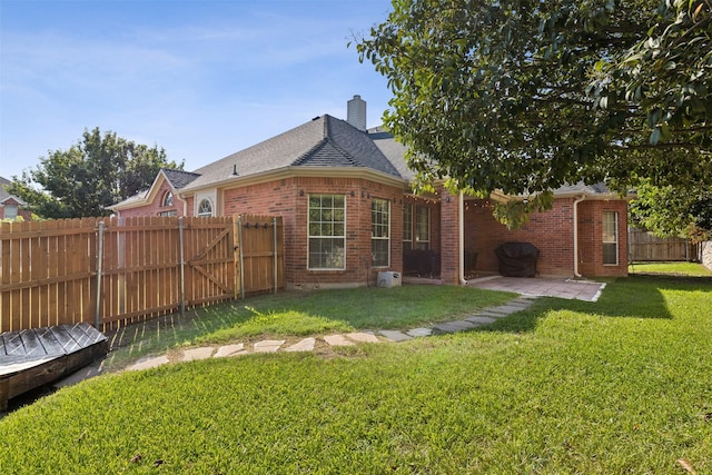 rear view of property featuring a patio area and a lawn