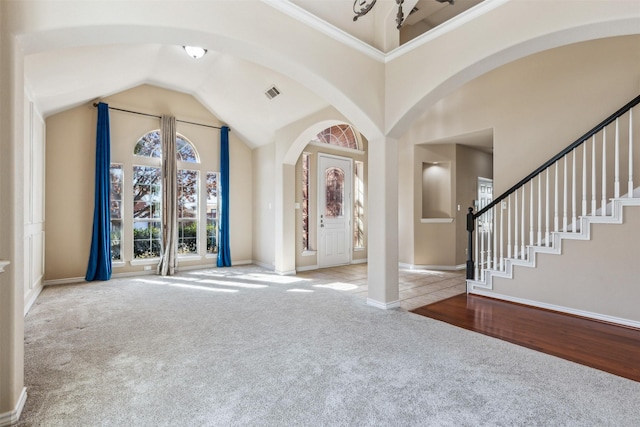 entryway with crown molding and light carpet