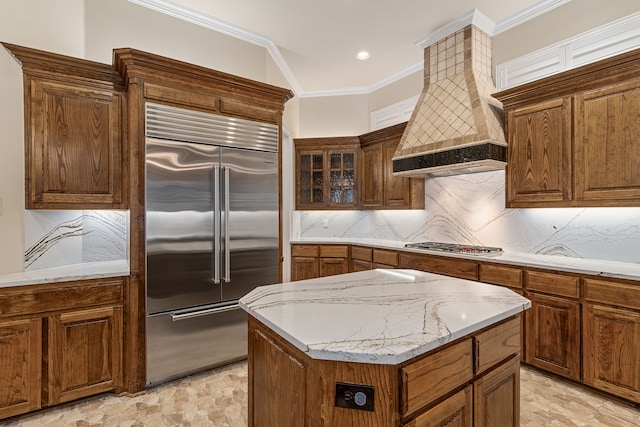 kitchen with premium range hood, a center island, tasteful backsplash, appliances with stainless steel finishes, and ornamental molding