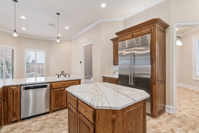 kitchen featuring hanging light fixtures, a center island, crown molding, appliances with stainless steel finishes, and sink