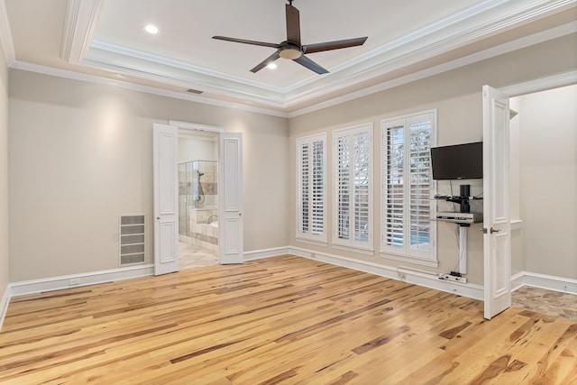 unfurnished bedroom featuring ceiling fan, light wood-type flooring, ensuite bathroom, and ornamental molding