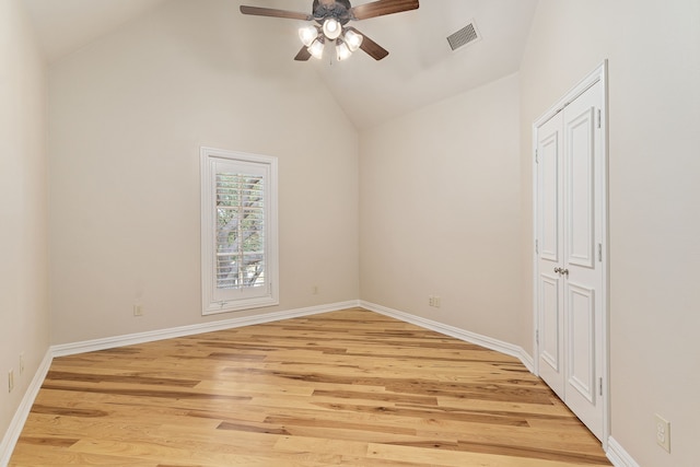 empty room featuring ceiling fan, light wood-type flooring, and high vaulted ceiling