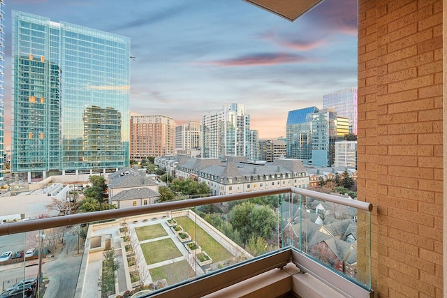 balcony at dusk featuring a view of city