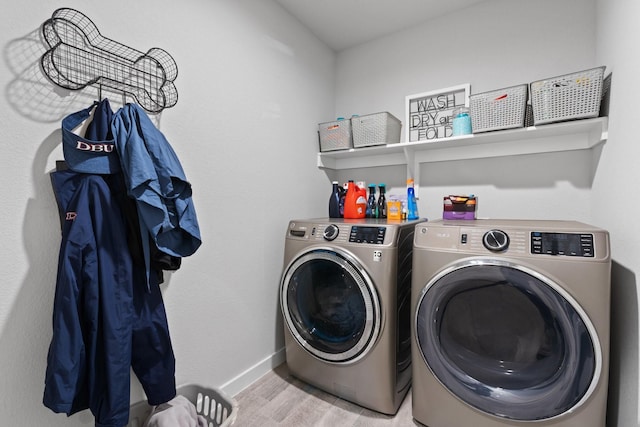 laundry area with washing machine and dryer and light hardwood / wood-style floors