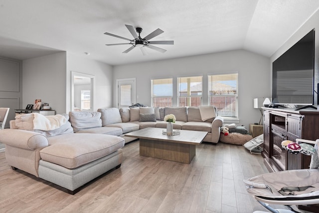 living room featuring lofted ceiling, ceiling fan, and light hardwood / wood-style flooring