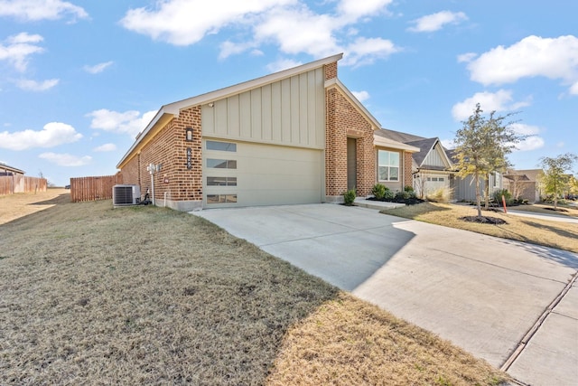 view of front facade featuring a garage, central air condition unit, and a front lawn