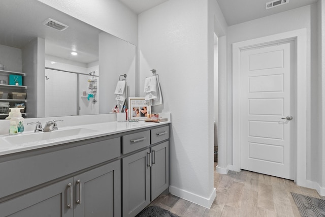 bathroom with walk in shower, wood-type flooring, and vanity