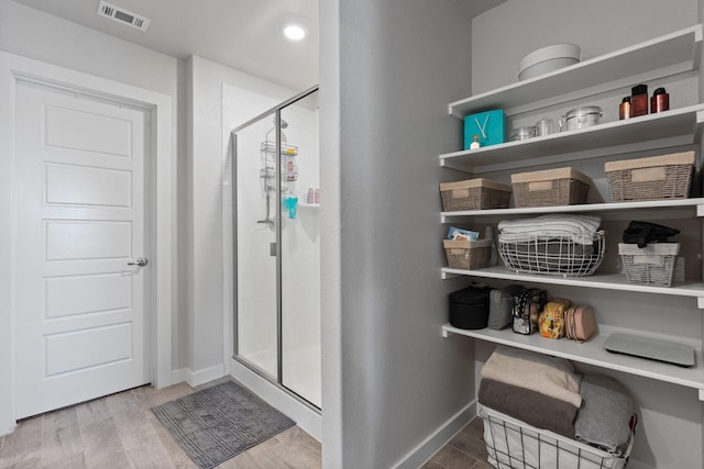 bathroom with walk in shower and wood-type flooring