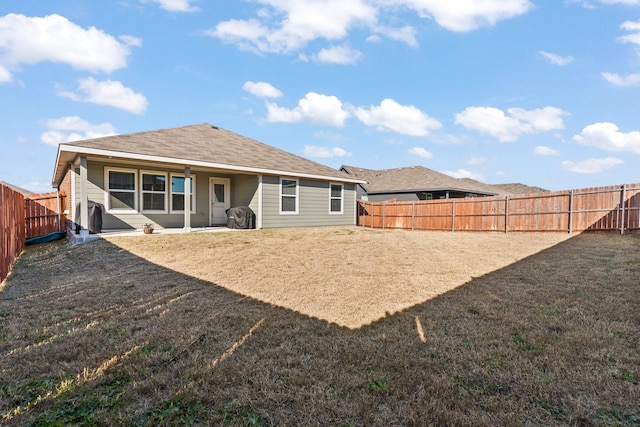 rear view of house featuring a yard and a patio