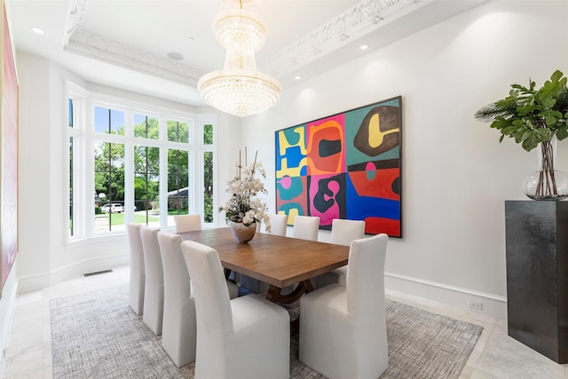 dining room with a tray ceiling and a notable chandelier